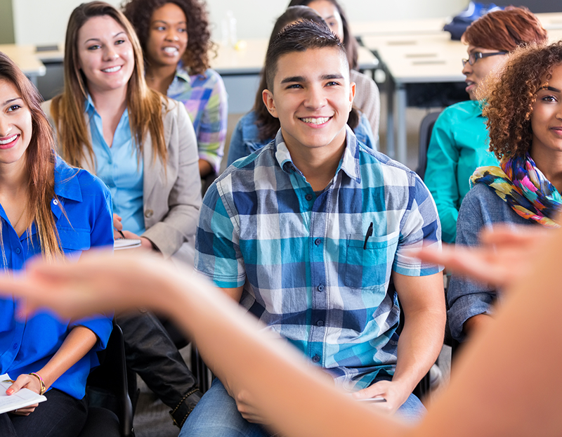 Students smile during lecture at desks