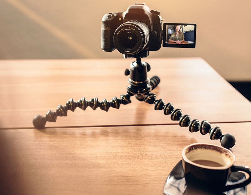 Camera sits on camera stand to record person speaking