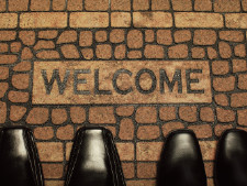 Shoes are featured in front of a welcome mat