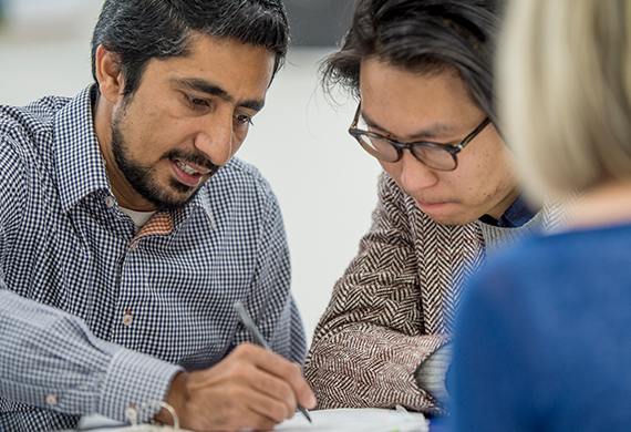 Middle-aged individuals collaborate over paper