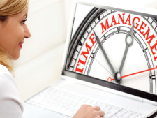 Person looks at computer screen which displays a clock with the words, "time management"