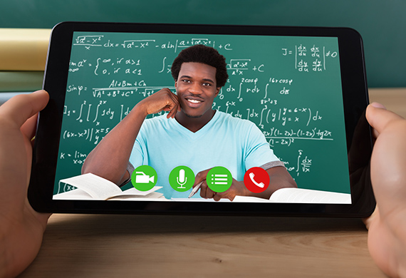 Person in front of chalkboard is featured on tablet on Zoom call