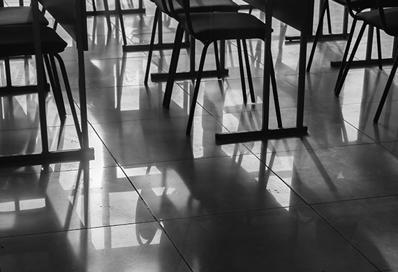 Empty classroom and empty chairs cast shadows