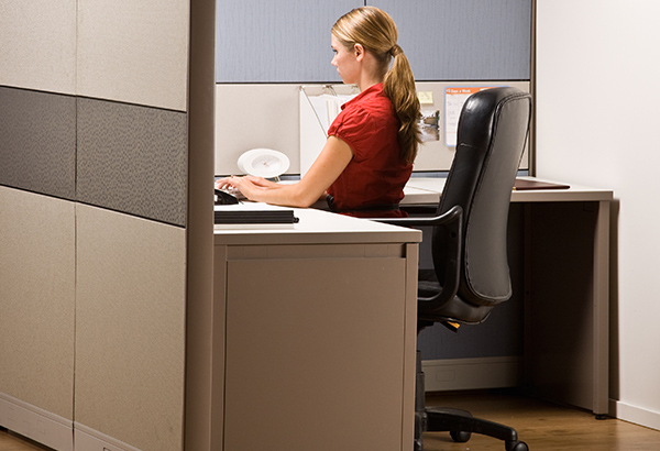 Person sits in office chair in cubicle