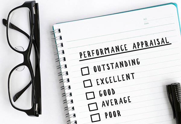 Notepad has the words, "performance appraisal" with checkboxes that indicate outstanding, excellent, good, average, or poor