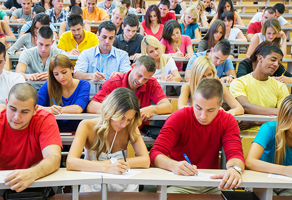 Large lecture hall filled with students all take exam