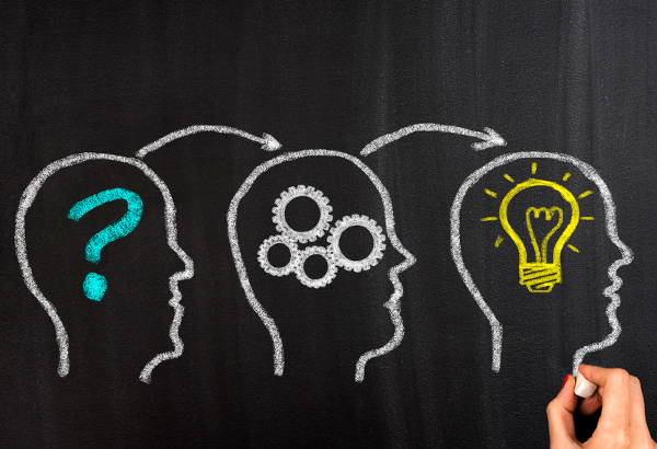 Chalkboard drawing of three heads consist of question mark, gears, and lightbulb