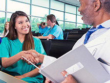 Student nurse shakes doctors hand during a lab for learning assessment techniques