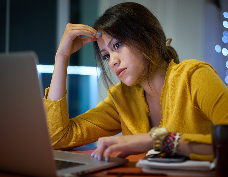 Female student looks at computer with misery with hand on head for Intellectual Development