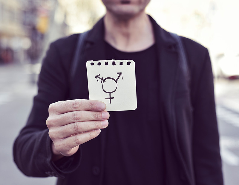 Person holds up notepad with transgender sign drawn on it