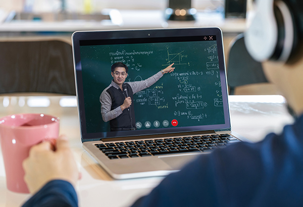 student-with-headphones-watching-instructor-teach-chalkboard