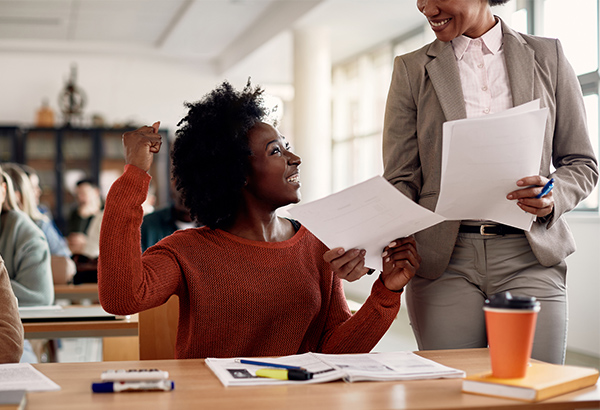 teacher-giving-paper-to-happy-student