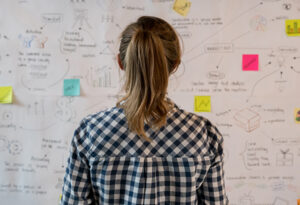 woman-looking-at-idea-board-notes-post-its