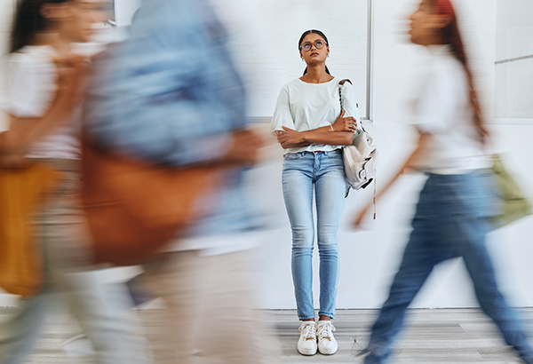 woman standing by herself while people move by