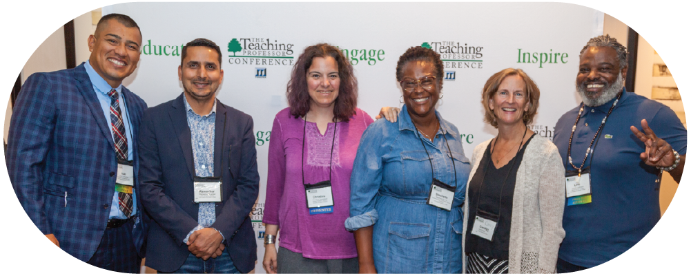 Six people smile in front of a Teaching Professor Conference step-and-repeat backdrop